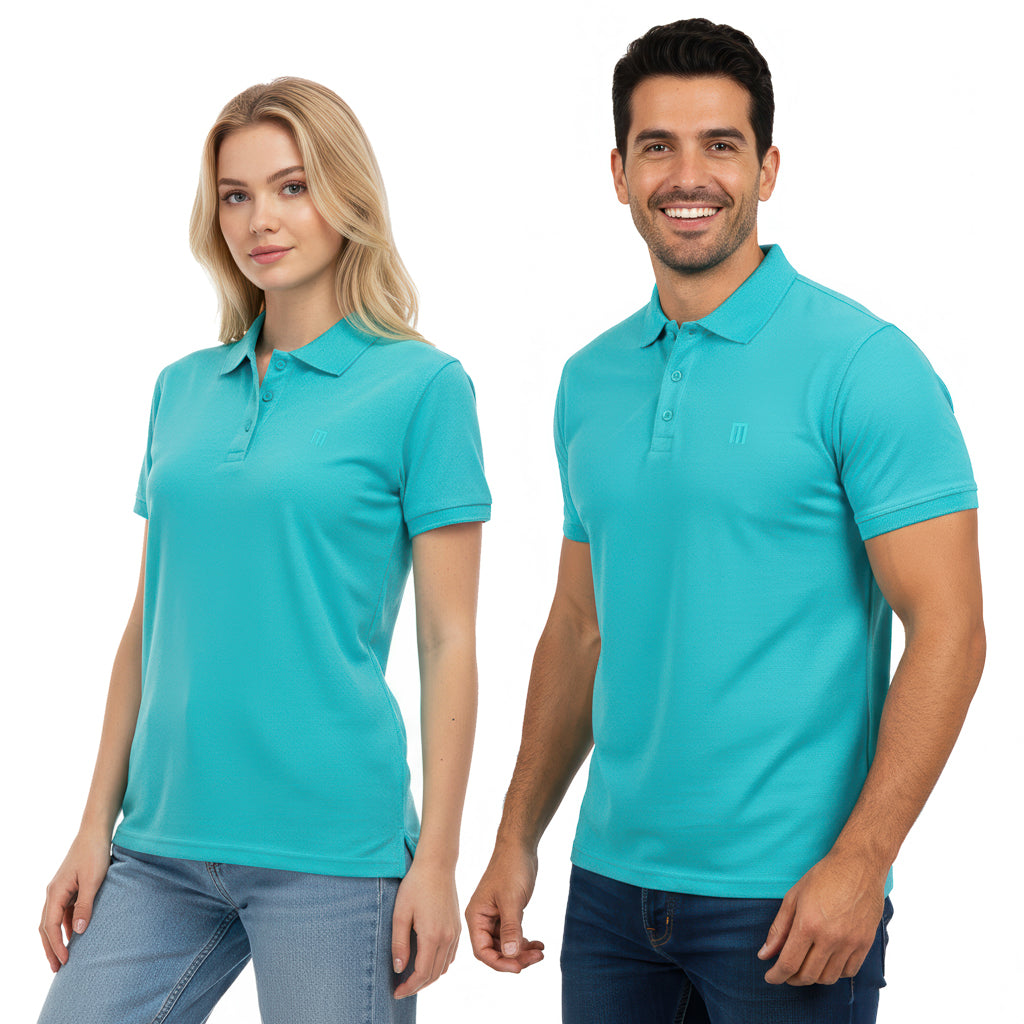 Smiling man and woman are posing together against a white background, both wearing matching turquoise polo shirts and jeans.