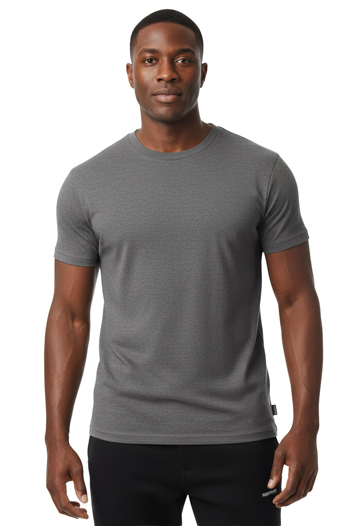 man with a short haircut and a neutral expression is shown wearing a solid dark gray t-shirt and black pants against a white background.