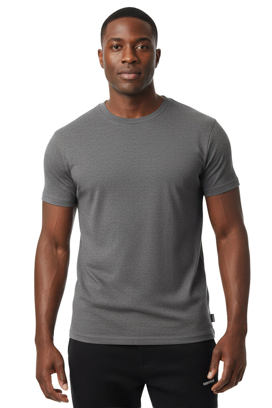 man with a short haircut and a neutral expression is shown wearing a solid dark gray t-shirt and black pants against a white background.