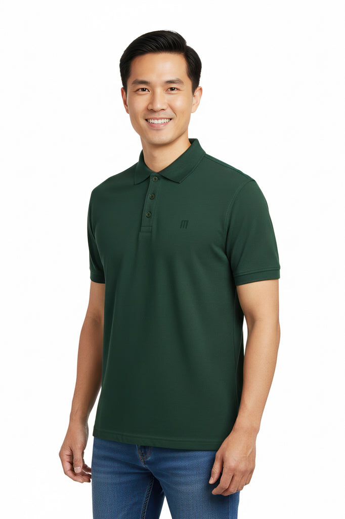 Smiling man with short dark hair wearing a dark green polo shirt and blue jeans against a white background.