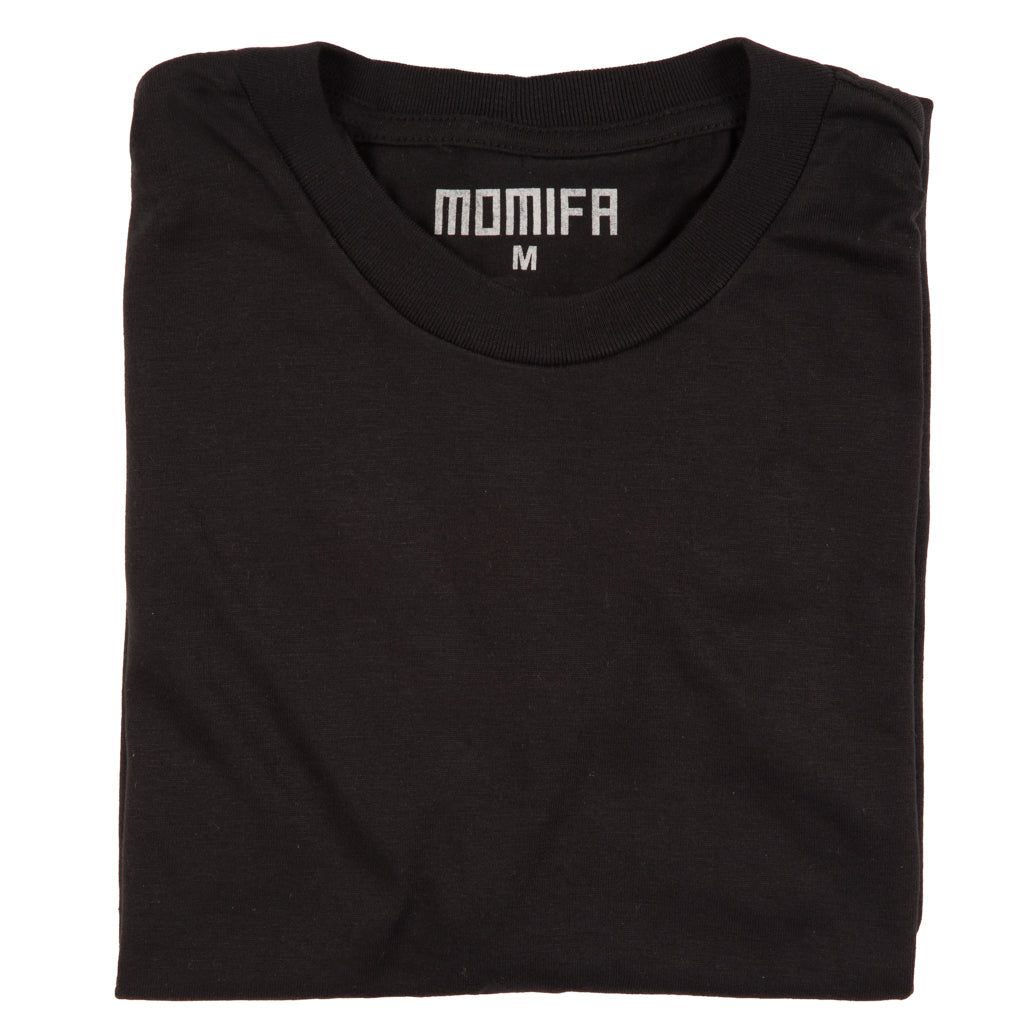 Folded black t-shirt with a white "MOMIFA M" logo on the collar label, placed against a dark background