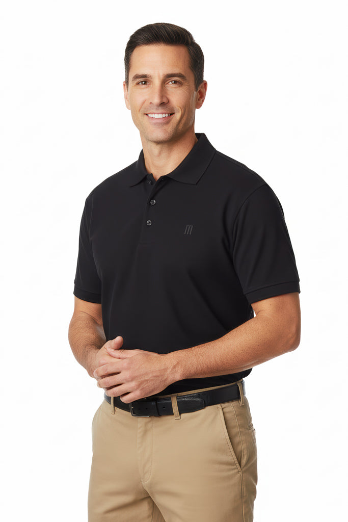smiling man with short dark hair wearing a black polo shirt with a subtle logo on the chest and beige pants with a black belt.