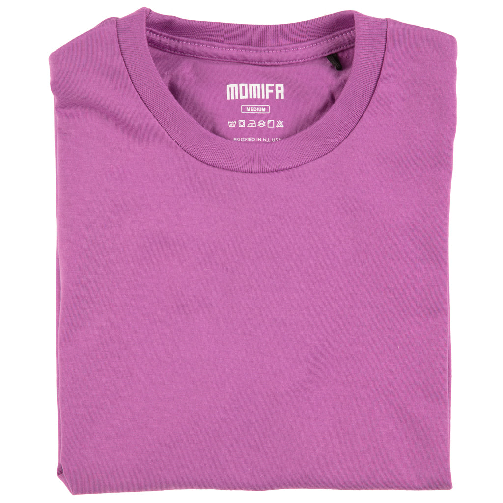 Folded, plain purple t-shirt is shown with a white brand label that reads "MOMIFA MEDIUM" on the collar.
