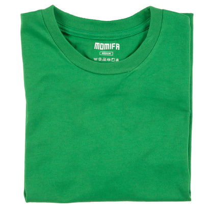 Green t-shirt with a white label in the neck. The label shows the brand "MOMIFA", size "MEDIUM", and laundry symbols.