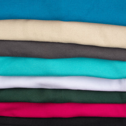 Folded solid-colored fabric pieces, including blue, beige, grey, turquoise, white, green, pink, and black.