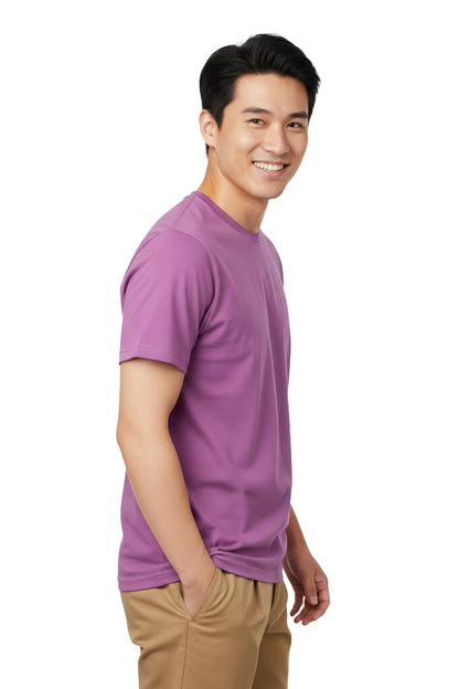 Smiling man wearing a purple t-shirt and khaki pants, posing with his hand in his pocket.