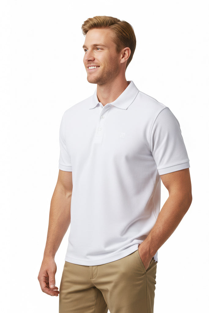 Smiling man with short light hair wearing a white polo shirt and beige pants, with one hand in his pocket.